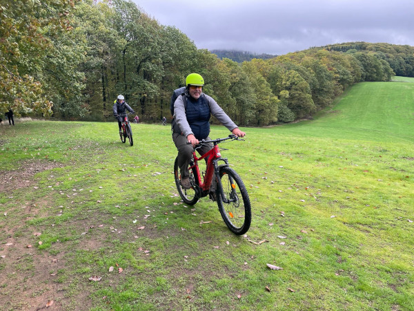 Mountainbiker fährt über eine Wiese