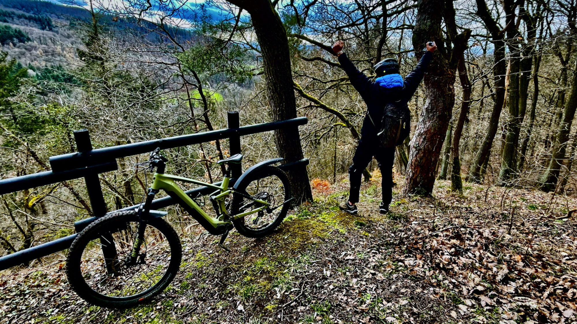 Mountainbiker reisst die Arme hoch und freut sich