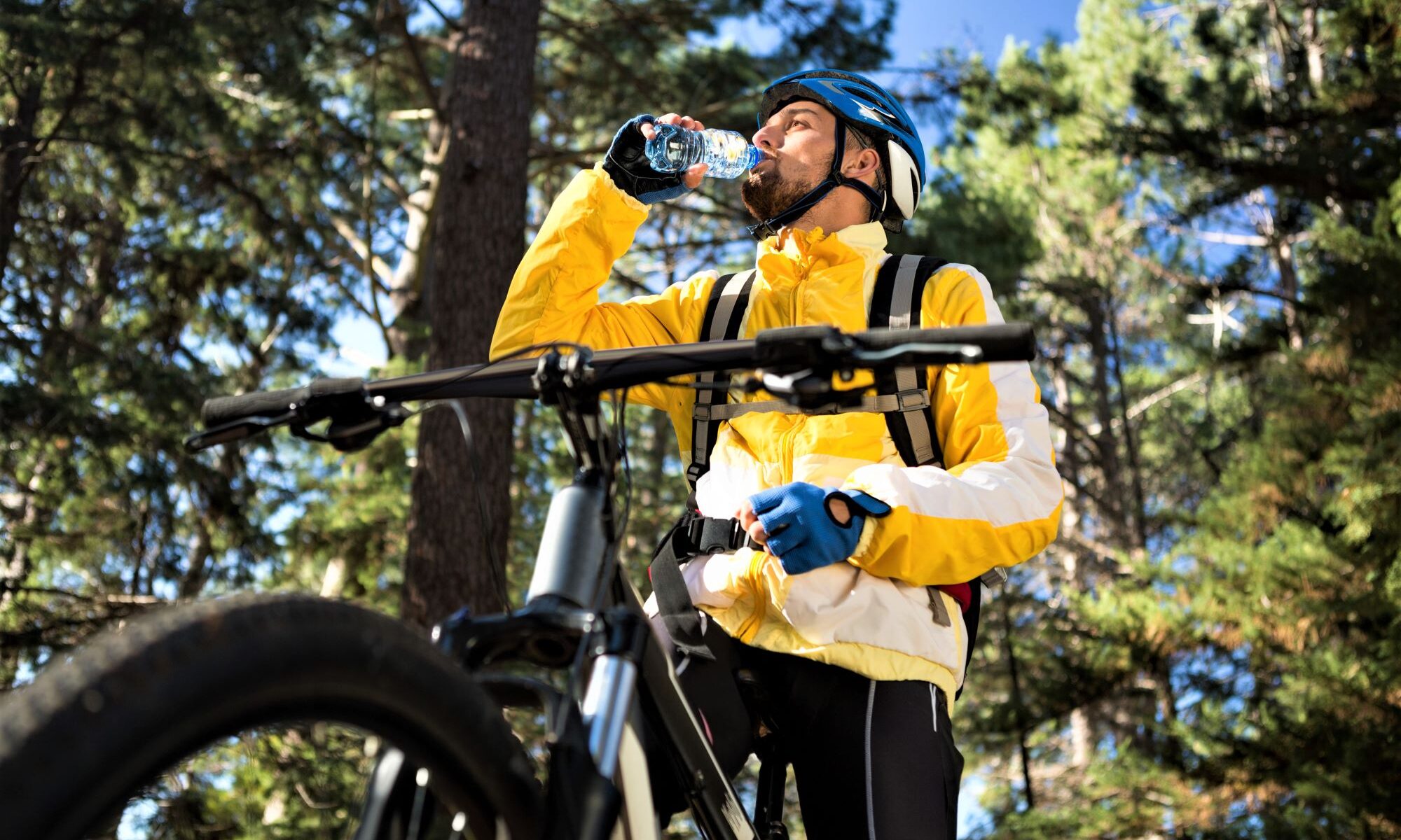 Mountainbiker im Wald trinkt etwas