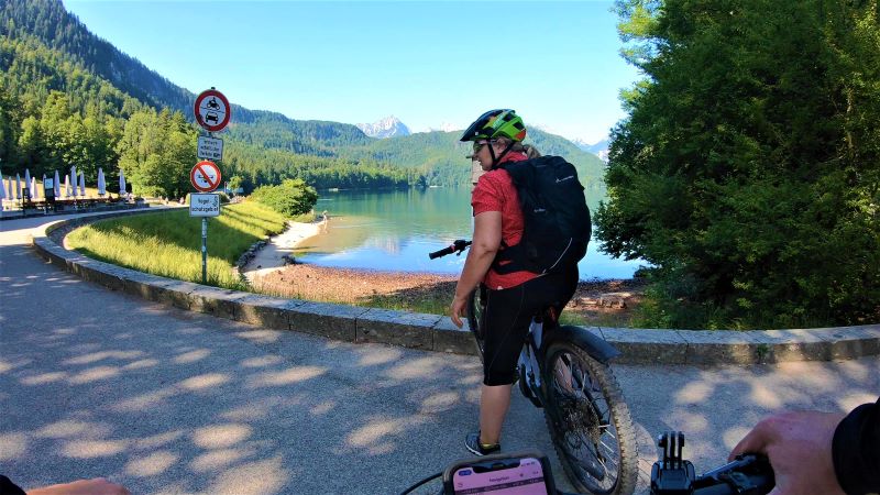 Radfahrerin am Ufer des Alpsees