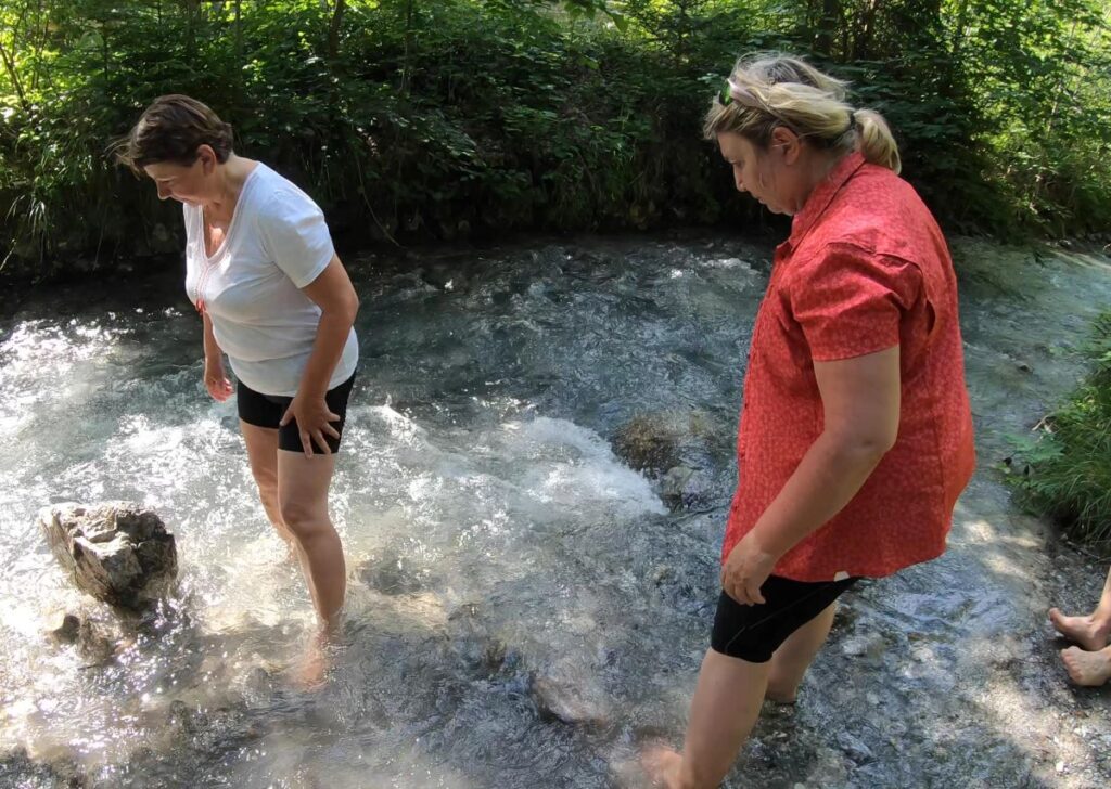 Menschen kühlen die Füße in einem Wildbach