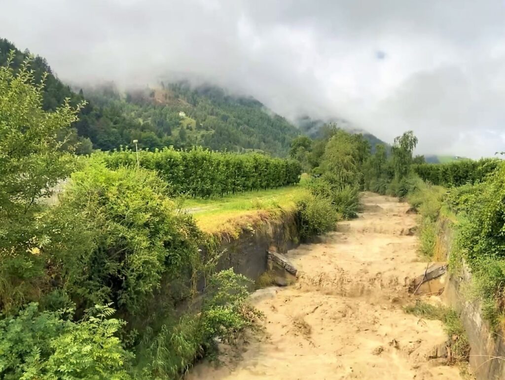 Regenwolken über einem Bach mit Hochwasse