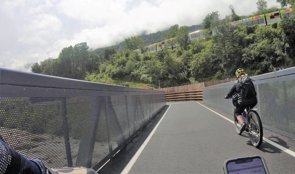 Radfahrerin auf Brücke über die Etsch