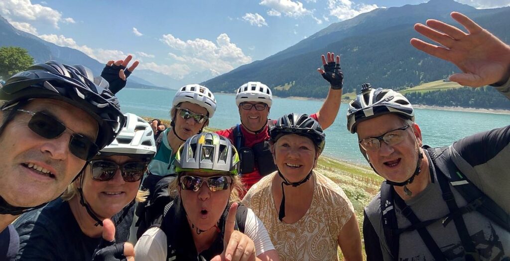 Selfie einer Gruppe Radfahrer vor dem Reschensee