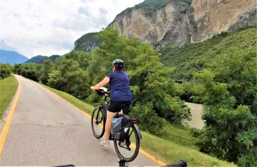 Fahrradfahrerin auf Radweg vor einem Berg