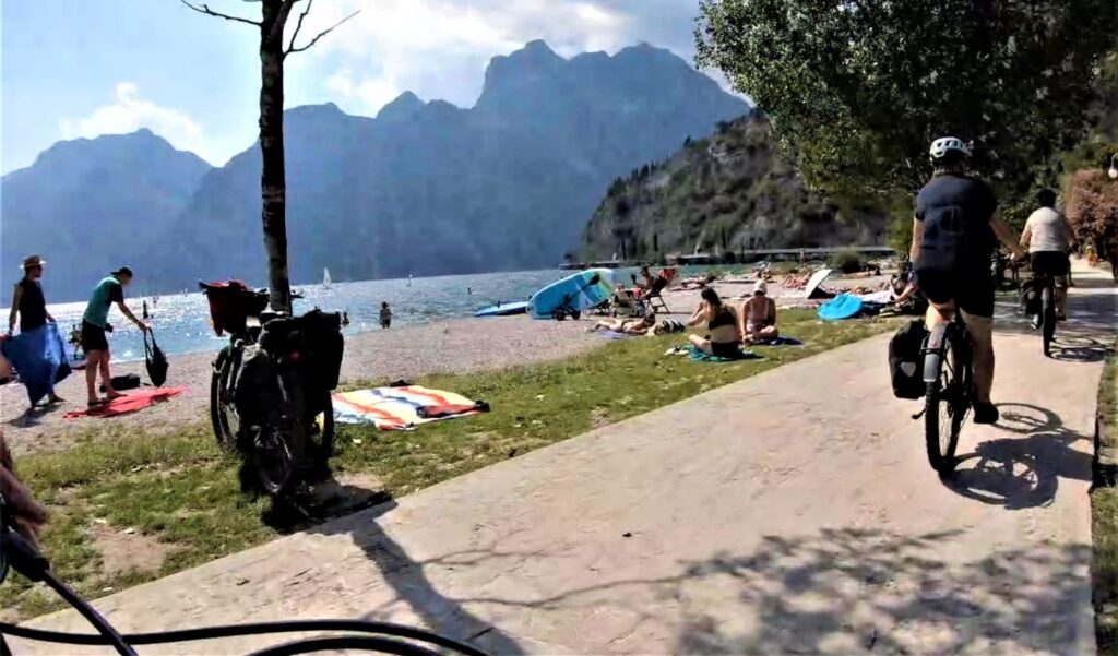 Badestrand am Uferpromenade in Torbole mit Fahrradfahrerin