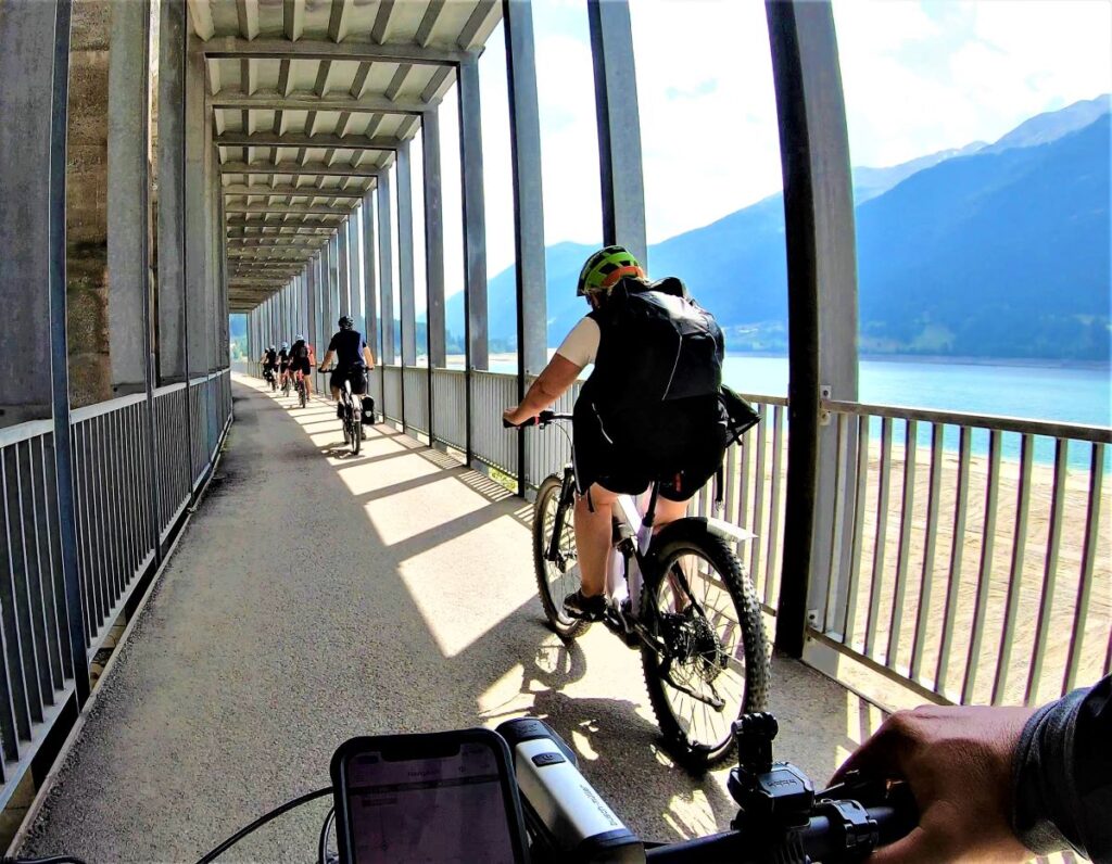 Radweg über dem Reschensee mit Gruppe Radfahrer