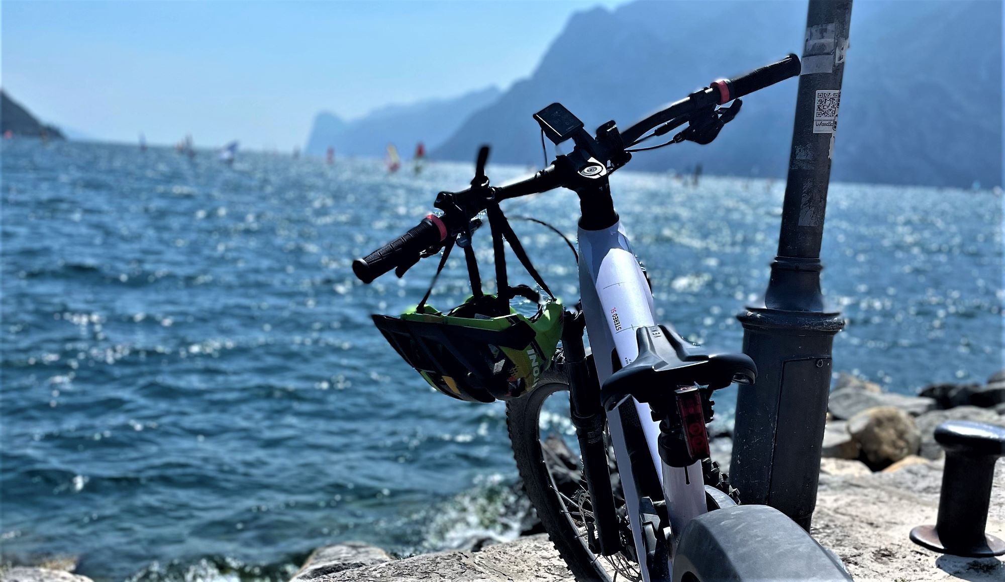 Fahrrad am Ufer des Gardasees in Torbole vor Steilküste