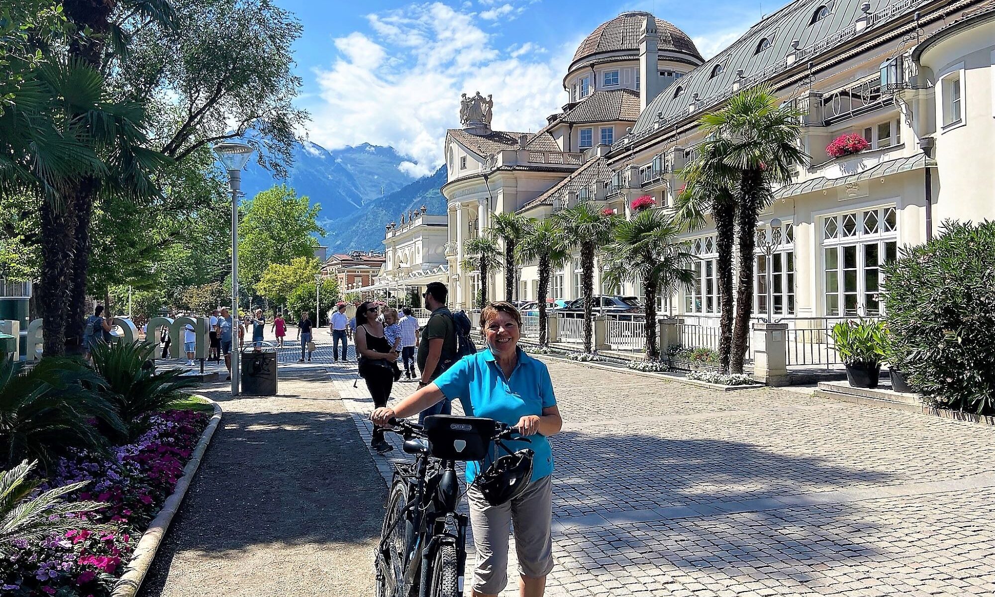 Kurhaus und Promenade Meran mit Radfahrerin