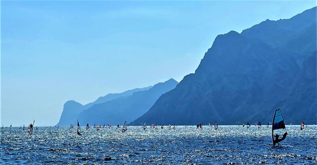 Windsurfer auf dem Gardasee bei Torbole vor Steilküste im Hintergrund