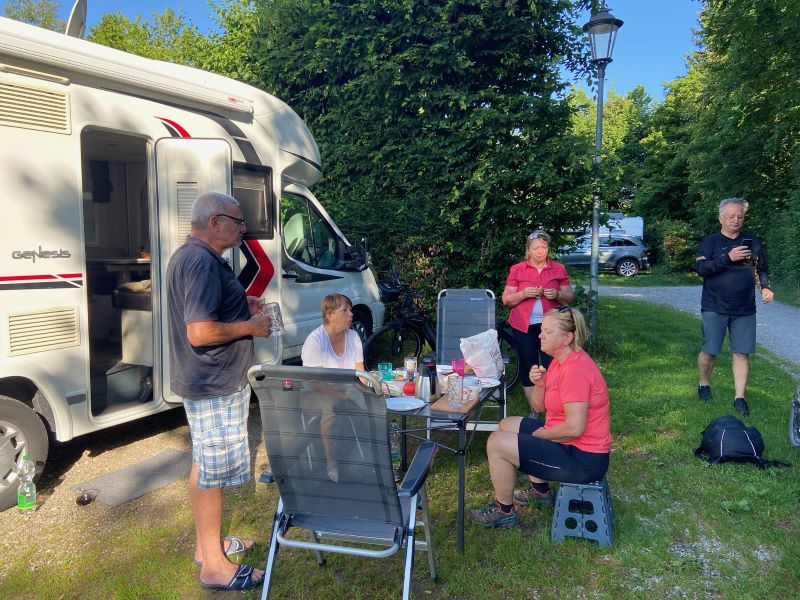 Gruppe am Tisch vor Wohnmobil