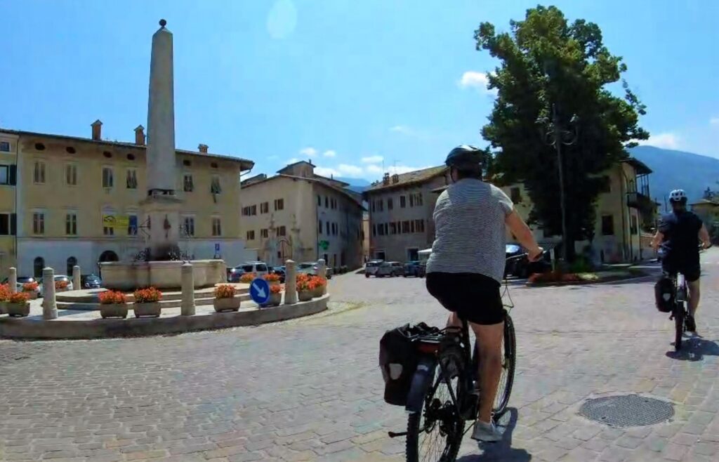 Platz in Rovereto mit Radfahrerin im Vordergrund.