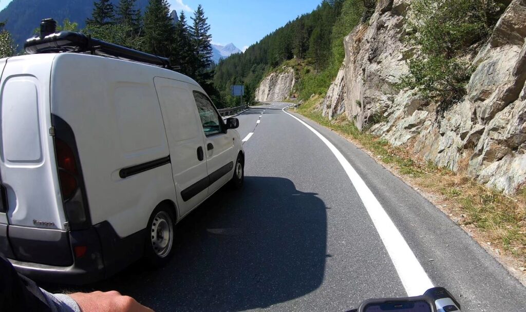 Ein Auto überholt einen Radfahrer